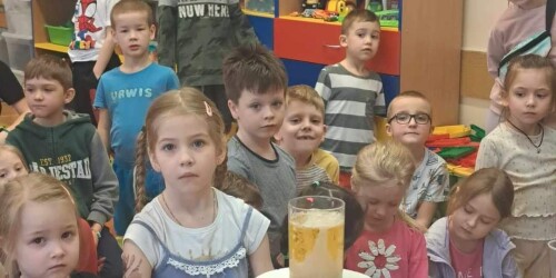 dzieci obserwują eksperyment wykonywany w szklance