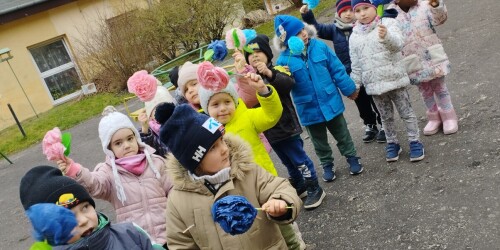 dzieci idą na spacer z kwiatami wykonanymi z bibuły