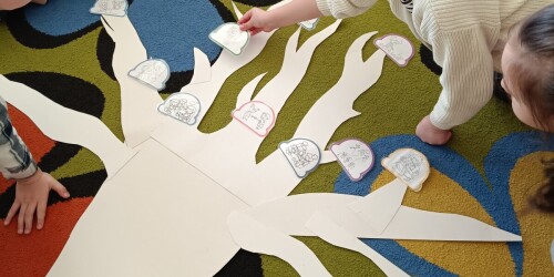 dzieci układają obrazki na drzewku wyciętym z papieru