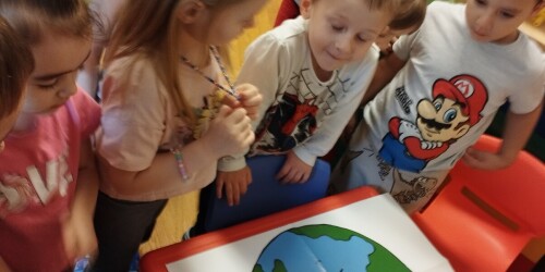 dzieci przyglądają się plakatowi z okazji Dnia Ziemi